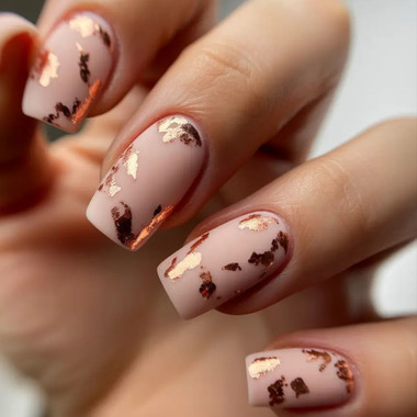 Beautiful beige manicure with gold leaf