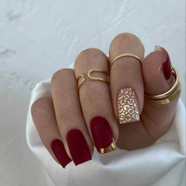 Matte rote Maniküre mit goldenem Dekor