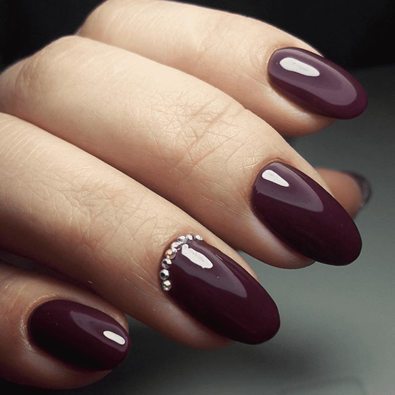 Dunkelrote Maniküre (mit Strasssteinen)