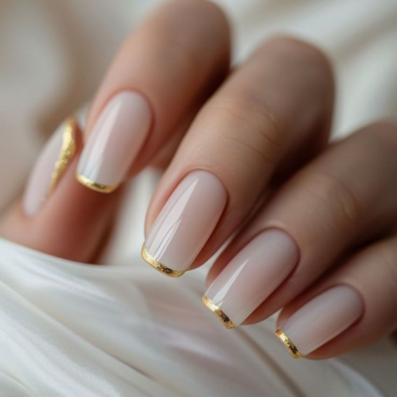 Milchige Maniküre mit goldenen Spitzen