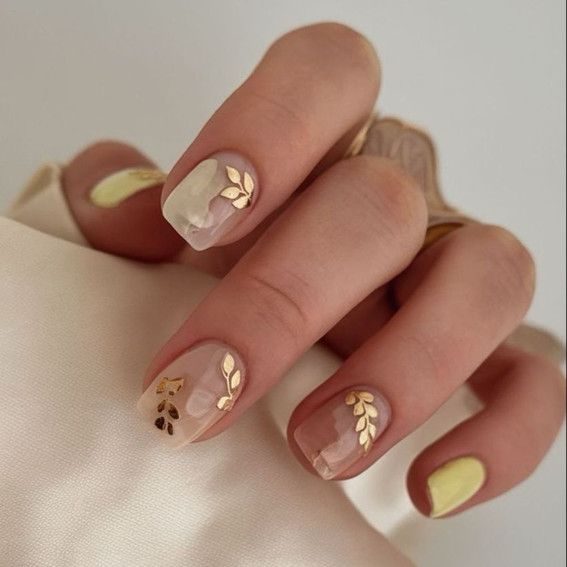 Zarte milchige Maniküre mit goldenen Blättern