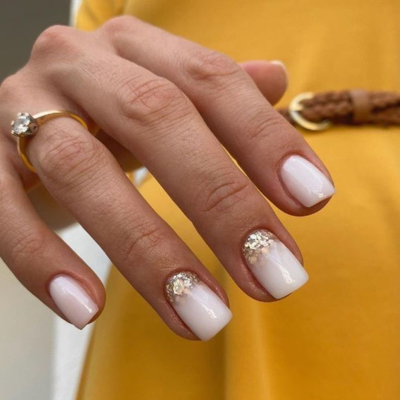 Milchige Maniküre mit goldenem Glitzer